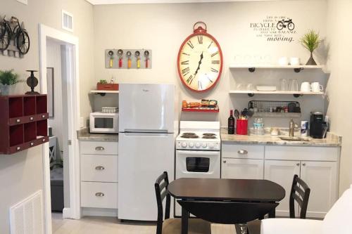 a kitchen with a table and a clock on the wall at Cozy Apartment Overlooking Downtown and Park NO KIDS, NO PETS in Dunedin