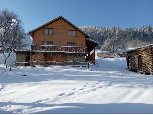 una casa en la nieve con huellas en la nieve en Smerekova Hata, en Oryavchyk