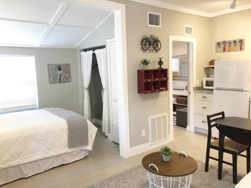 a bedroom with a bed and a table and a kitchen at Cozy Apartment Overlooking Downtown and Park NO PETS in Dunedin