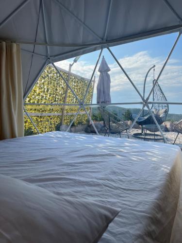 a bed in a tent with a view at Stone Rose Glamping & Apartments in Tivat