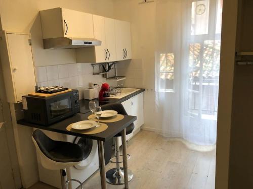 a small kitchen with a table and a microwave at Suite Saint Rome in Toulouse