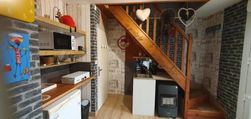 uma cozinha com uma escada num quarto em Guim appart em Guimiliau