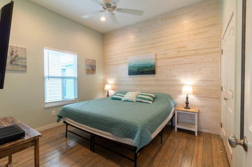 a bedroom with a bed and a wooden wall at Beach Bungalow - 2 Suns in Port Aransas
