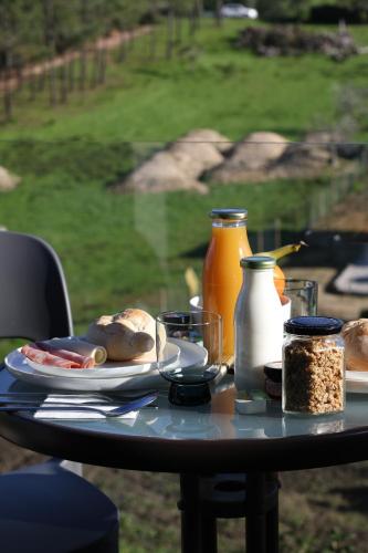 een tafel met een bord eten en sinaasappelsap bij Zambujal Suites in Sesimbra