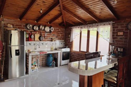 a kitchen with a refrigerator and a counter in it at Villa Don Alonso: Casa de Campo in Penipe