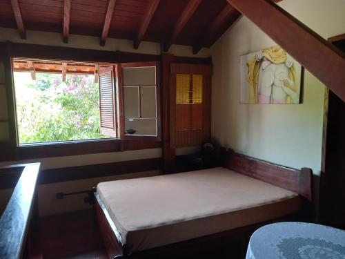 a small room with a bed and a window at CASA em UBATUBA in Ubatuba
