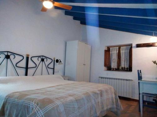 a bedroom with a large bed and a blue ceiling at Hostal los Aromas in Villena