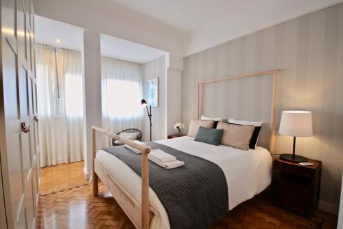 sypialnia z dużym łóżkiem i dużym oknem w obiekcie Akicity Amoreiras Jade w Lizbonie
