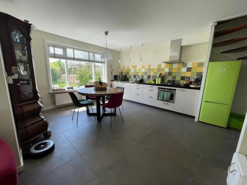 a kitchen with a table and some chairs in a room at Familiehuis Dacha op de Slufterweg in De Cocksdorp