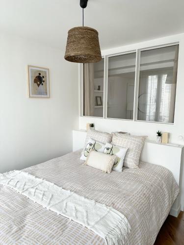- une chambre avec un lit doté d'oreillers et d'un miroir dans l'établissement Appartement central niché en centre-ville, à Saint-Germain-en-Laye