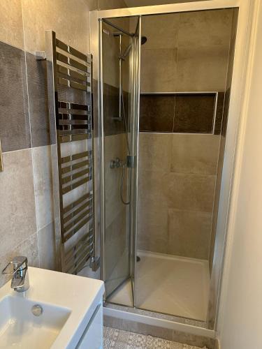 une douche avec une porte vitrée dans une salle de bain dans l'établissement Appartement central niché en centre-ville, à Saint-Germain-en-Laye