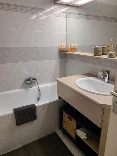 une salle de bain avec un lavabo et une baignoire dans l'établissement T2 climatisé à 5 minutes à pied de la plage avec parking, piscine et wifi, à Fréjus