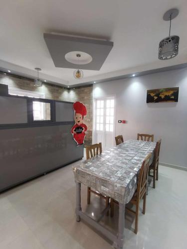 a dining room with a table with a chef on the wall at Dream Garden Luxor in Luxor