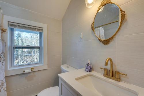 uma casa de banho com um lavatório, um espelho e um WC. em Inviting Chittenden Apartment Near Pico Mountain! em Chittenden