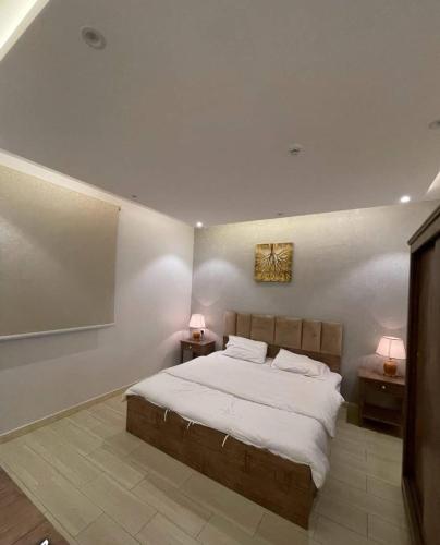 ein Schlafzimmer mit einem großen Bett und zwei Nachttischen in der Unterkunft شاليهات الود in Abha