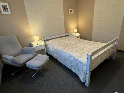 um quarto de hospital com uma cama e duas cadeiras em Großzügige Wohnung mit Schreibtischarbeitsplatz in Genthin OT Tucheim em Tucheim