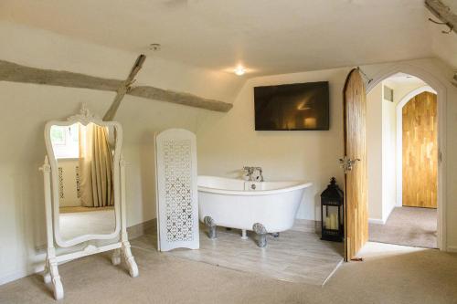 een badkamer met een wit bad in een kamer bij Sheene Mill in Melbourn