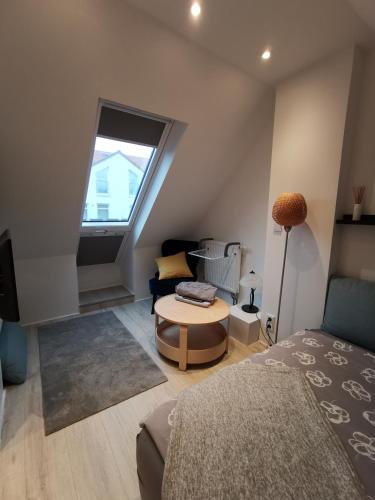 ein Wohnzimmer mit einem Sofa und einem Tisch in der Unterkunft Dachzimmer mit Kochecke und Duschbad, nahe Messe in Hannover