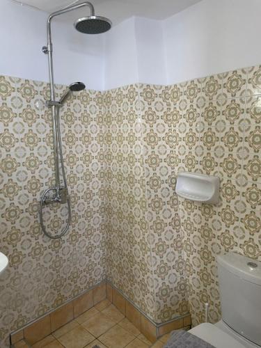 uma casa de banho com um chuveiro e um WC. em Chrisopetro Rooms em Marathokampos