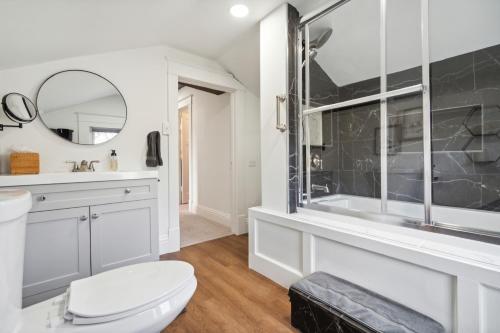 a bathroom with a toilet and a sink and a mirror at Cottage on Main in Lansdale