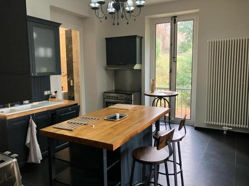 a kitchen with a wooden table and two bar stools at Villa Morton - Domaine du Grand Tourmalet Pic du Midi in Bagnères-de-Bigorre