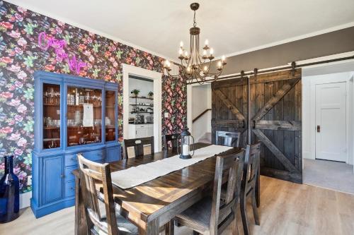 a dining room with a blue table and a floral wall at Cottage on Main in Lansdale