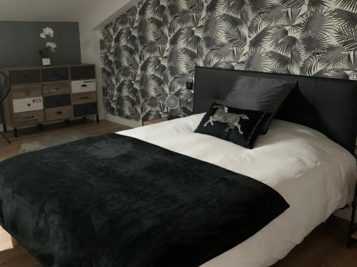 - une chambre avec un grand lit et une couverture noire dans l'établissement Gîte paisible proche du Mans avec piscine privée, 4 chambres, Wi-Fi et parking gratuit - FR-1-410-428, à Montfort-le-Gesnois