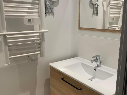 une salle de bain avec un lavabo blanc et un miroir dans l'établissement Gîte paisible proche du Mans avec piscine privée, 4 chambres, Wi-Fi et parking gratuit - FR-1-410-428, à Montfort-le-Gesnois