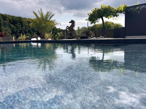 une grande piscine d'eau dans une cour dans l'établissement Gîte paisible proche du Mans avec piscine privée, 4 chambres, Wi-Fi et parking gratuit - FR-1-410-428, à Montfort-le-Gesnois