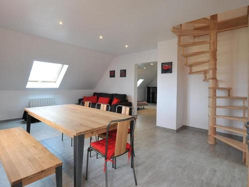 une salle à manger avec une table en bois et des chaises rouges dans l'établissement Gîte lumineux et calme avec terrasse, barbecue et parking à 5 km de Colmar - FR-1-744-32, à Houssen