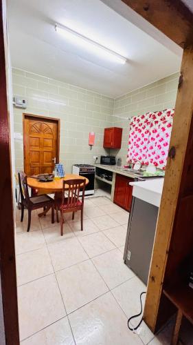 Villa Anse Possession في باي سانت آن: مطبخ مع طاولة وكراسي في غرفة