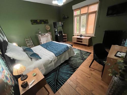 ein Schlafzimmer mit einem Bett, einem Schreibtisch und einem Stuhl in der Unterkunft Vers le soleil levant in Croisilles