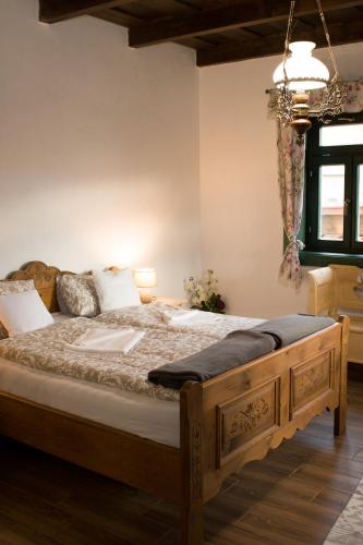 a bedroom with a large wooden bed in a room at Pinkó Vendégház in Noszvaj