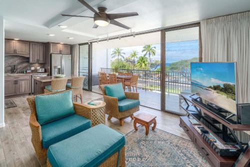 a living room with a flat screen tv and a kitchen at Maui Parkshore 410 - Stunning Ocean Views in Wailea