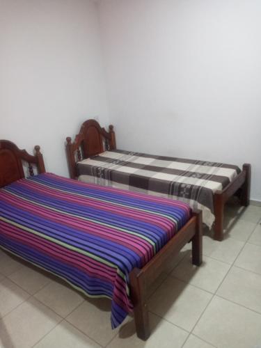 - deux lits assis l'un à côté de l'autre dans une pièce dans l'établissement monoambiente, à Jesús María