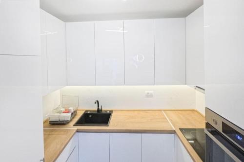 a kitchen with white cabinets and a sink at Urban Haven in Ledine