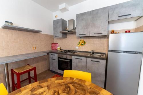 a kitchen with a table and a refrigerator at DA ERIK E NICHI in Negrar