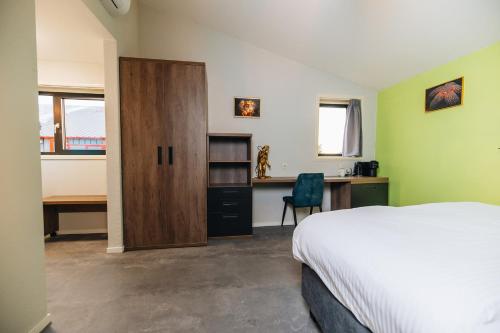 Schlafzimmer mit einem Bett, einem Schreibtisch und einem Schrank in der Unterkunft Duikresort Sub Ocean Hotel in Oud-Vossemeer