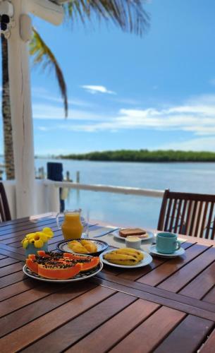 a table with plates of food on a table with a view of the water at Restaurante & Pousada Gaivota in Santo André