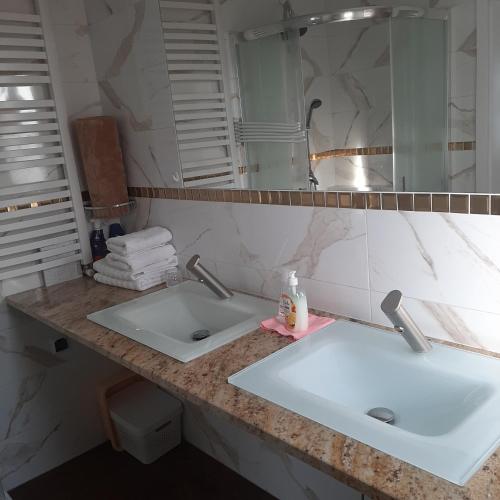 a bathroom counter with two sinks and a mirror at Roztocze 3 kroki od sosny in Zamość