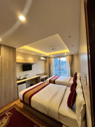um quarto de hotel com duas camas e uma cozinha em Hotel prime suite em Catmandu
