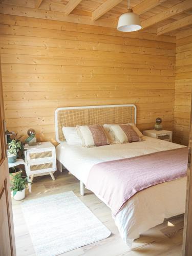 1 dormitorio con 1 cama en una pared de madera en Sítio dos Carvalhos, en Covide