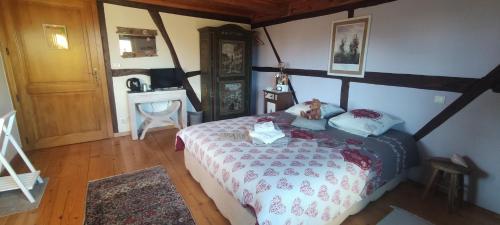 ein Schlafzimmer mit einem Bett mit einem Teddybär drauf in der Unterkunft Au Verger des Louves 