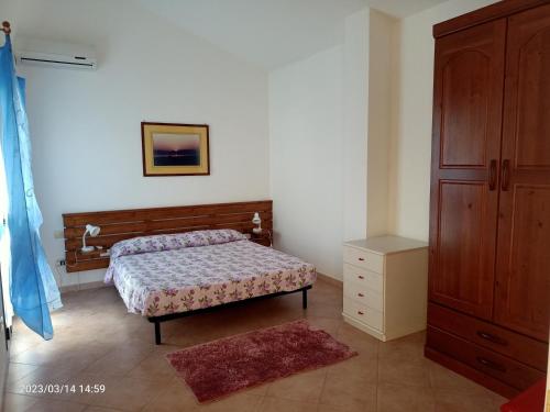 1 dormitorio con 1 cama, armario y alfombra en Appartamenti Regina Margherita, en Calasetta