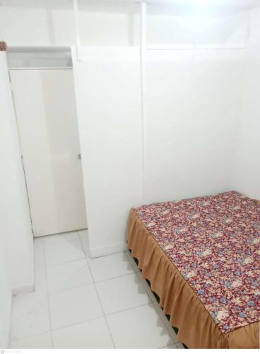 - une chambre avec un lit dans une pièce aux murs blancs dans l'établissement Habitación Privada, Br. El Nogal Armenia Quindío, Colombia, à Armenia