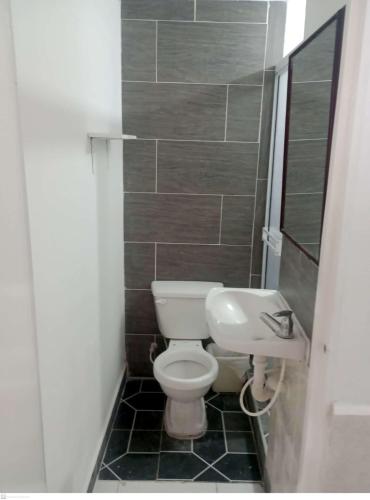 La petite salle de bains est pourvue de toilettes et d'un lavabo. dans l'établissement Habitación Privada, Br. El Nogal Armenia Quindío, Colombia, à Armenia