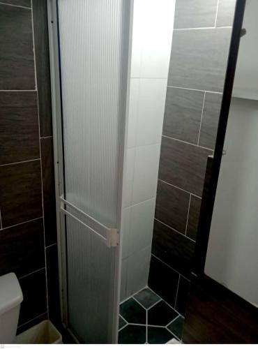 La salle de bains est pourvue d'une douche avec une porte en verre. dans l'établissement Habitación Privada, Br. El Nogal Armenia Quindío, Colombia, à Armenia