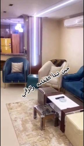 sala de estar con 2 sillas azules y mesa en Mini VELLA ALJWHARA en Al Ḩammām