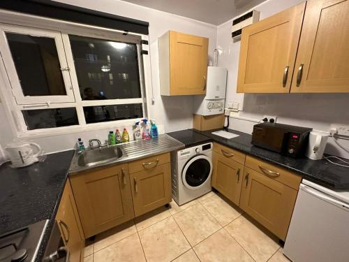 a kitchen with a sink and a washing machine at 3 Bedroom King Cross station City centre London in London