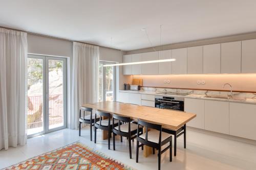 a kitchen with a wooden table and some chairs at L'Olivier 23 - 2 apartments in a recently renovated Guesthouse in Porto